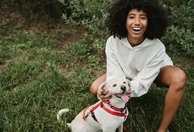 Dog and owner posing for a photo in field